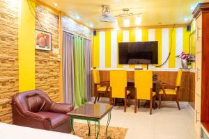 une salle à manger avec une table et des chaises jaunes dans l'établissement Amor Building - Urdaneta City, 