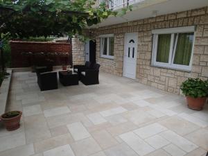 a patio with chairs and tables and a white door at Apartments Nicole in Pula