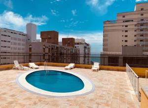 a swimming pool on the roof of a building at Boulevard Center in Guarujá