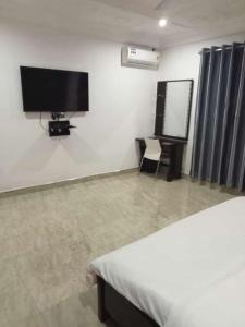 a bedroom with a flat screen tv on the wall at De-Cartos Hotel 