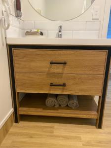 a bathroom vanity with a sink and a mirror at Norton Motel in Hamilton