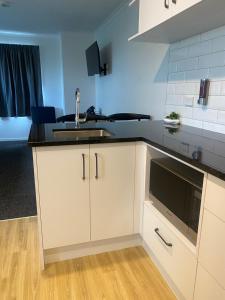 a kitchen with a sink and a microwave at Norton Motel in Hamilton