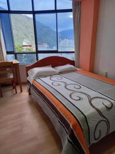 a bed in a room with a large window at Hostal Garcilaso - Garaje Amplio in Abancay
