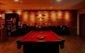 a red pool table in a room with a brick wall at Pousada Quinta dos Cabeças in Capitólio