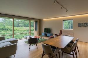 a living room with a wooden table and chairs at Miru Niseko in Niseko