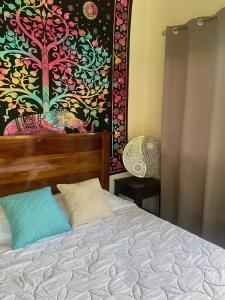 a bedroom with a bed with a painting on the wall at Apartamento con Terraza y Vista al Jardín in Uvita +38 photos