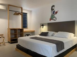 een slaapkamer met een groot wit bed in een kamer bij Hôtel Lune de Miel in Deshaies