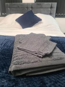 a pile of towels sitting on top of a bed at Homestay by BIC Legends 1 in Batley Carr