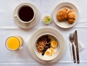 einen Tisch mit einer Schüssel Frühstücksprodukt und einer Tasse Kaffee in der Unterkunft 3H HOTEL Av 70 in Medellín