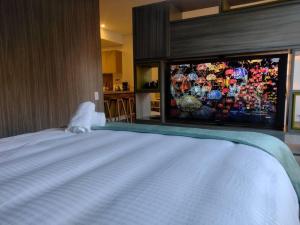 a bedroom with a large bed with a tv on the wall at Nuevo! Apartamento Oasis Central in Bogotá
