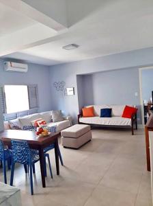 ein Wohnzimmer mit einem Sofa und einem Tisch in der Unterkunft Apartamento charmoso no centro de Ubatuba in Ubatuba