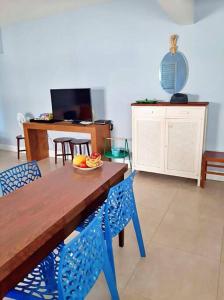 ein Esszimmer mit einem Holztisch und blauen Stühlen in der Unterkunft Apartamento charmoso no centro de Ubatuba in Ubatuba