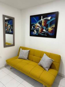 a yellow couch in a room with a painting on the wall at Habitacion independiente muy bien ubicado in Cartagena de Indias