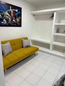 a living room with a yellow couch in a room at Habitacion independiente muy bien ubicado in Cartagena de Indias