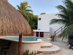 a resort with a swimming pool and a building at CASA DELFINES RIO LAGARTOS in Río Lagartos