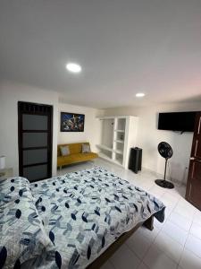 a bedroom with a bed and a couch in it at Habitacion independiente muy bien ubicado in Cartagena de Indias