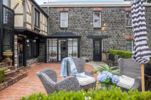 un patio con sedie in vimini e un edificio in mattoni di A Loft In The Mill Boutique Accommodation a Olinda