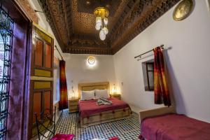 a bedroom with a bed and a ceiling at Riad Qamar Fez in Fès