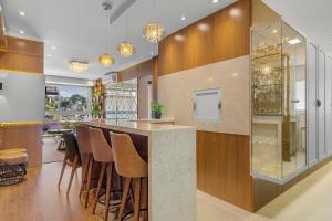 a kitchen with a bar with stools at Vita Boulevard Luxo 2 Suítes by Achei Gramado in Gramado