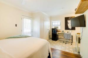 a bedroom with a bed and a desk and a television at Cozy Houston Studio with Pool Access! in Houston