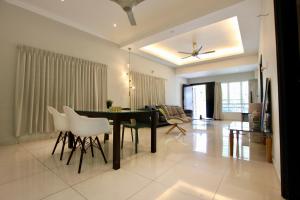 a dining room and living room with a table and chairs at Stradford Stay Melaka in Melaka