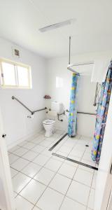 a white bathroom with a toilet and a window at Spicer Caravan Park in Parkes