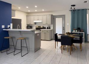 a kitchen with white cabinets and a table and chairs at Chic, Quiet 2BR 2BA Near Shops & Restos! in McAllen