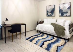a bedroom with a bed and a desk and a table at Chic, Quiet 2BR 2BA Near Shops & Restos! in McAllen