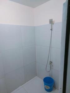 uma casa de banho com um chuveiro com um balde azul em Rendezvous Beach Resort - Cabongaoan em Tambobong