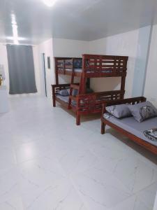um quarto com três beliches num quarto em Rendezvous Beach Resort - Cabongaoan em Tambobong