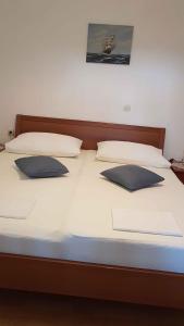 a bed with two pillows on top of it at Apartment in Lopar/Insel Rab 17757 in Lopar