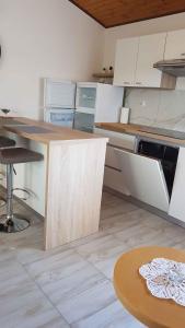a kitchen with white cabinets and a wooden table at Apartment in Lopar/Insel Rab 17757 in Lopar
