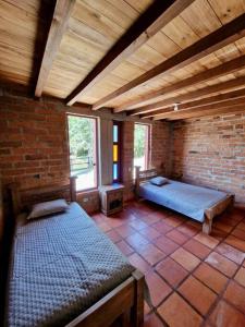 um quarto com duas camas e uma parede de tijolos em Finca La Alcazaba 