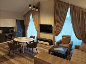 una sala de estar con un sofá, una mesa y sillas en Sweet villa Palanga, en Palanga