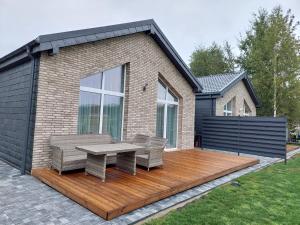 Una terraza de madera con dos sillas y una mesa. en Sweet villa Palanga, en Palanga