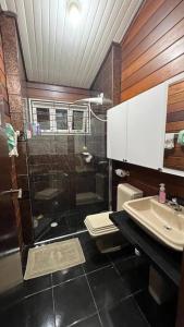 Un baño con ducha, inodoro y lavabo. en Chalé Flamingo com Piscina Casa inteira em Morretes, en Morretes