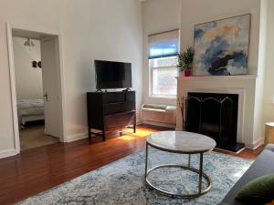 a living room with a table and a fireplace at The Orange House in Washington, D.C.