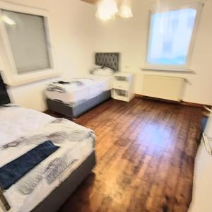 um quarto com 2 camas e piso em madeira em FMI 15,Furnished Accommodation em Bischofsheim