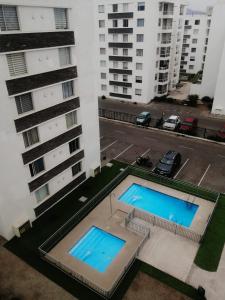 two swimming pools in the middle of two buildings at Cond. Portal pacifico III in La Serena