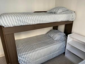 a bunk bed with a pillow and a ottoman at Cond. Portal pacifico III in La Serena