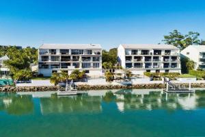 a view of two large white buildings next to a body of water at Commodore Apartment 5, Noosa Heads in Noosa Heads