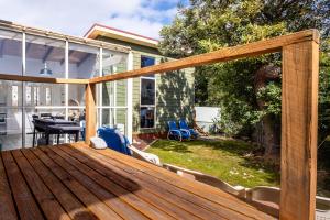 una terraza con mesa y sillas de madera en Mayson en Coles Bay
