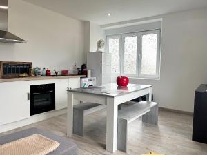 a kitchen with a table with a red apple on it at Cocon lumineux près des pistes in La Bresse