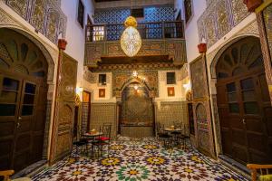 Riad Qamar Fez في فاس: غرفة مزخرفة مع أرضية بلاط وأبواب