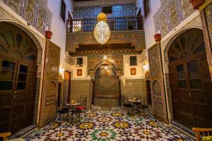 an ornate room with a tile floor and doors at Riad Qamar Fez in Fez