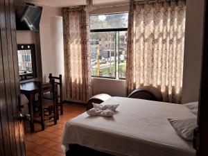 Habitación de hotel con 2 camas y ventana en LAS ARTES INN en Lima