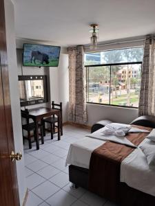 a bedroom with a bed and a table and a window at LAS ARTES INN in Lima