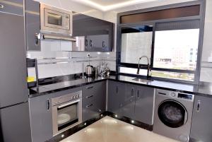 a kitchen with stainless steel appliances and a washer and dryer at Casa Hamburg in Nador