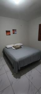 1 cama en una habitación blanca con 2 cuadros en la pared en Chácara Mount Sinai en Ubajara