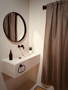 a bathroom with a sink and a mirror and a shower curtain at Indajani Hotel&Hostel Tulum with Pool in Tulum